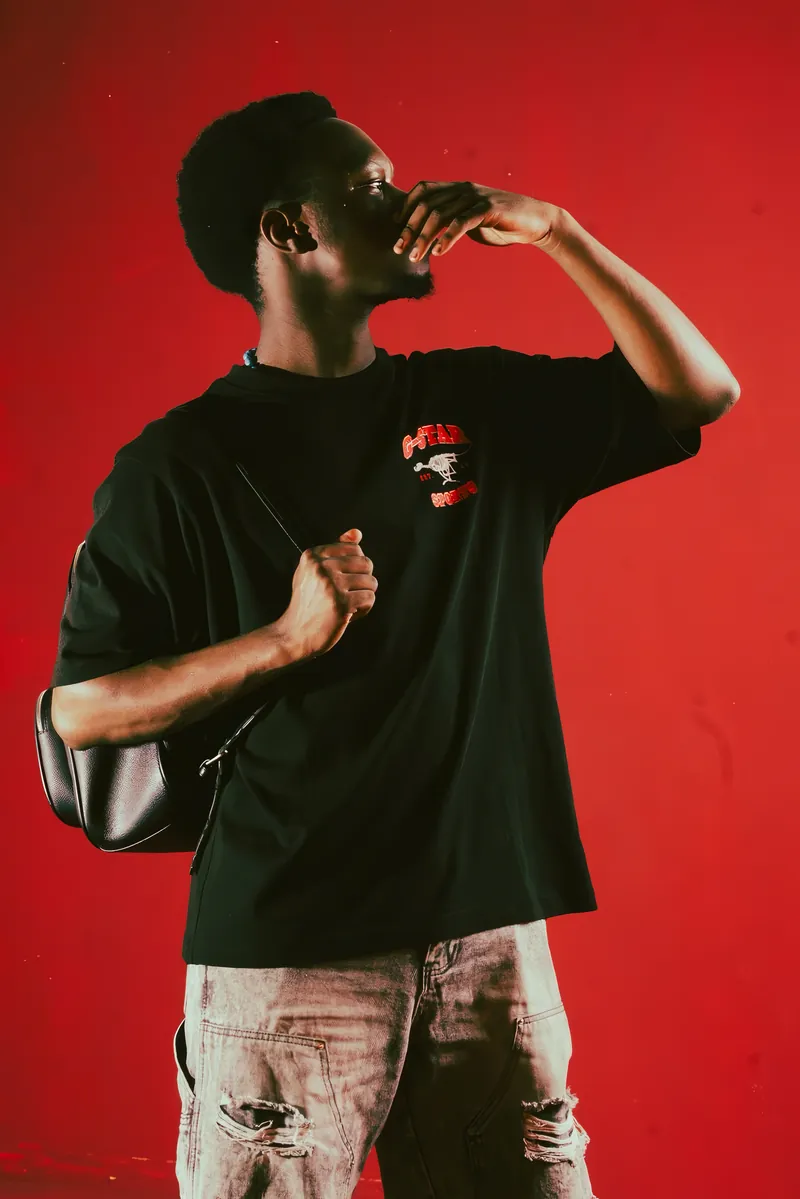 Tame Tiger photographed in a red studio wearing black